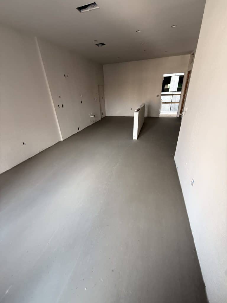 Finished gypsum underlayment surface in a building unit