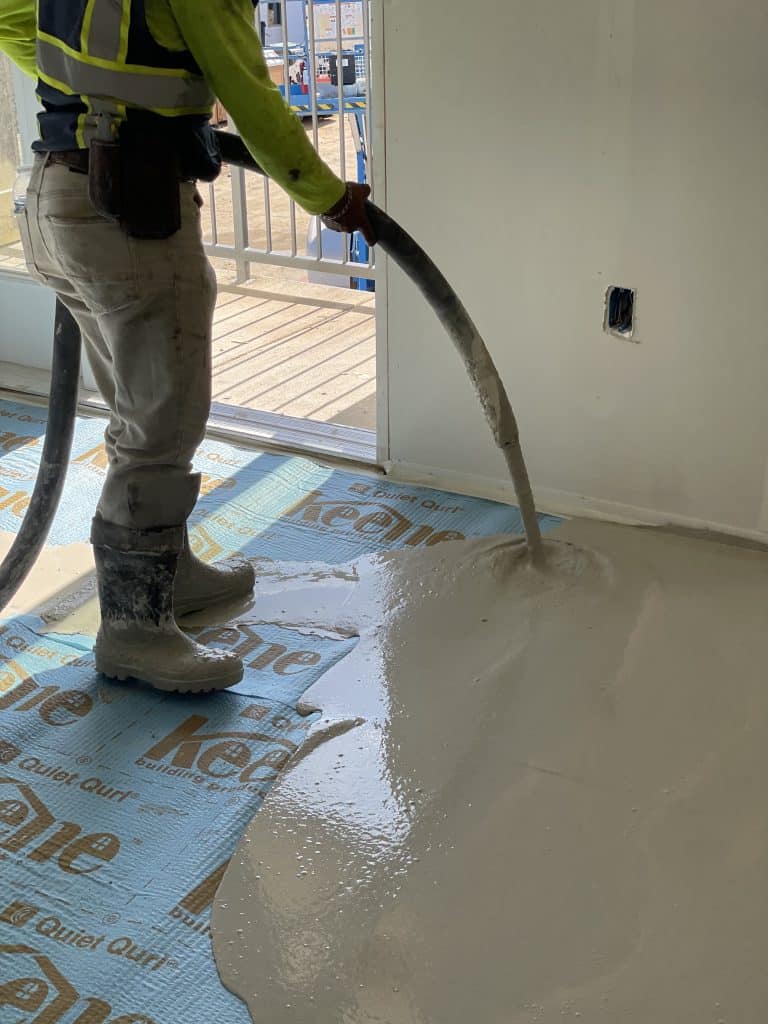 Gypsum underlayment being poured over sound mat